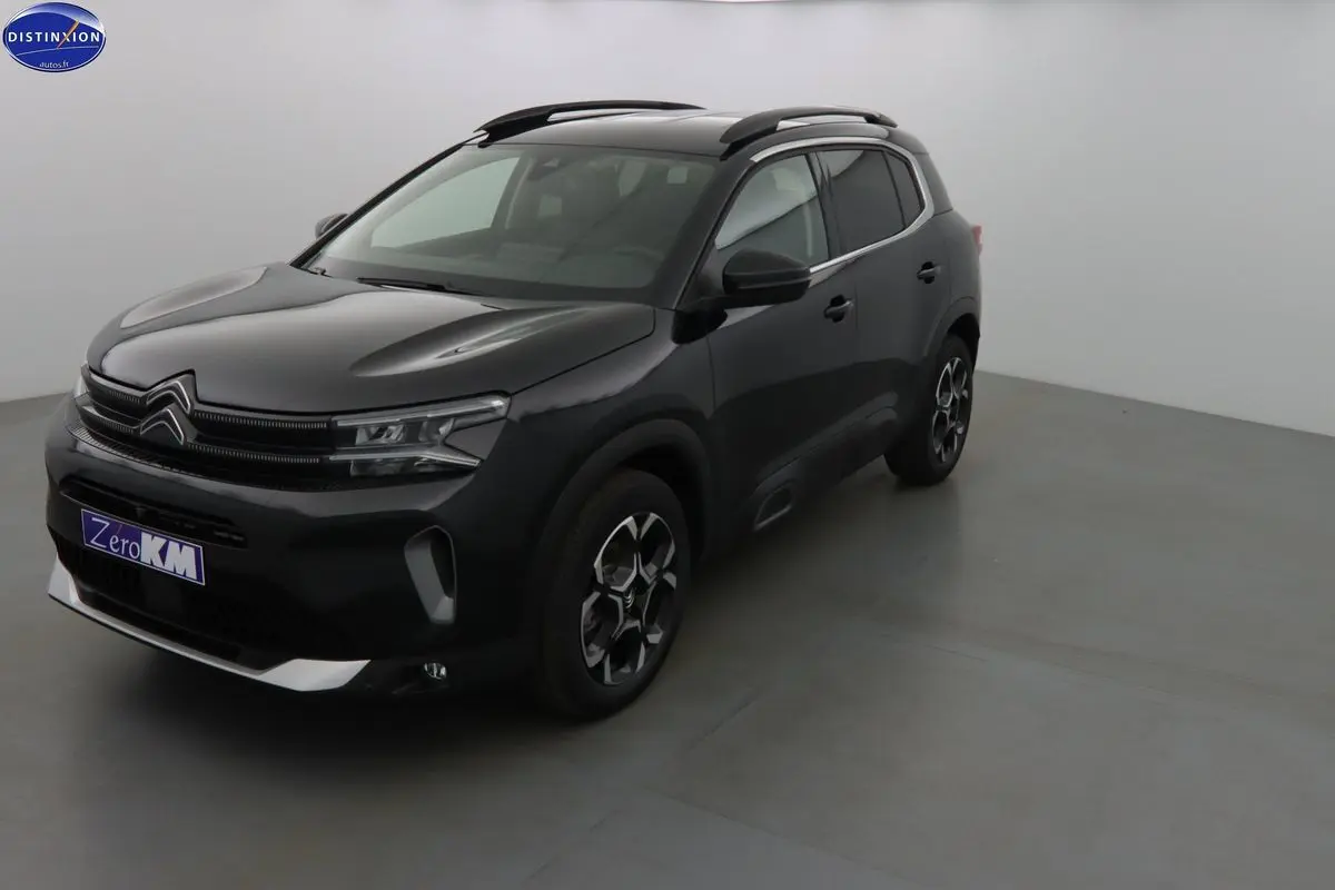 Citroën C5 Aircross noir perle vu en 3/4 avant droit, avec jantes bi-ton et barres de toit noires.