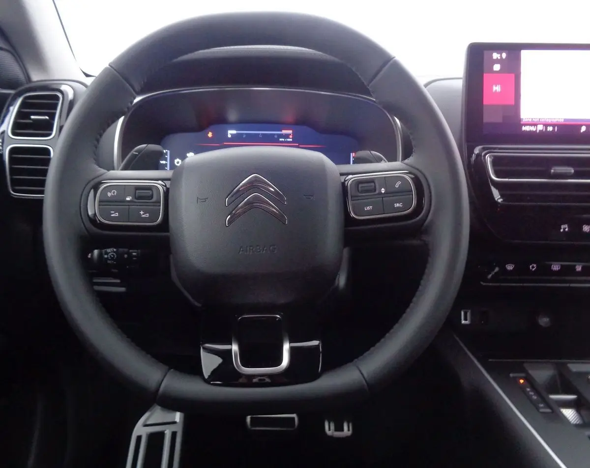 Vue centrée sur le volant noir du Citroën C5 Aircross 2022 avec commandes intégrées et tableau de bord numérique.