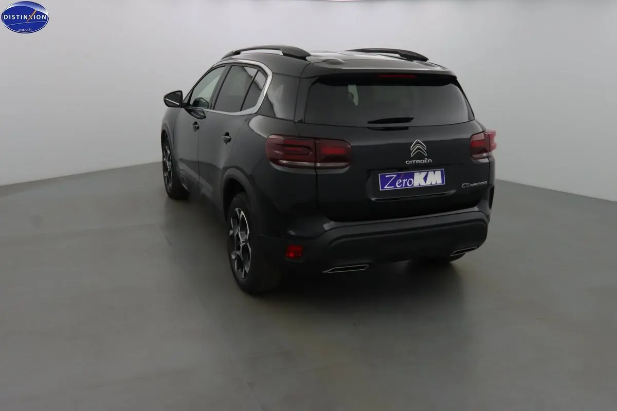 Vue 3/4 arrière d'un Citroën C5 Aircross noir perle avec feux arrière caractéristiques et jantes bi-ton.