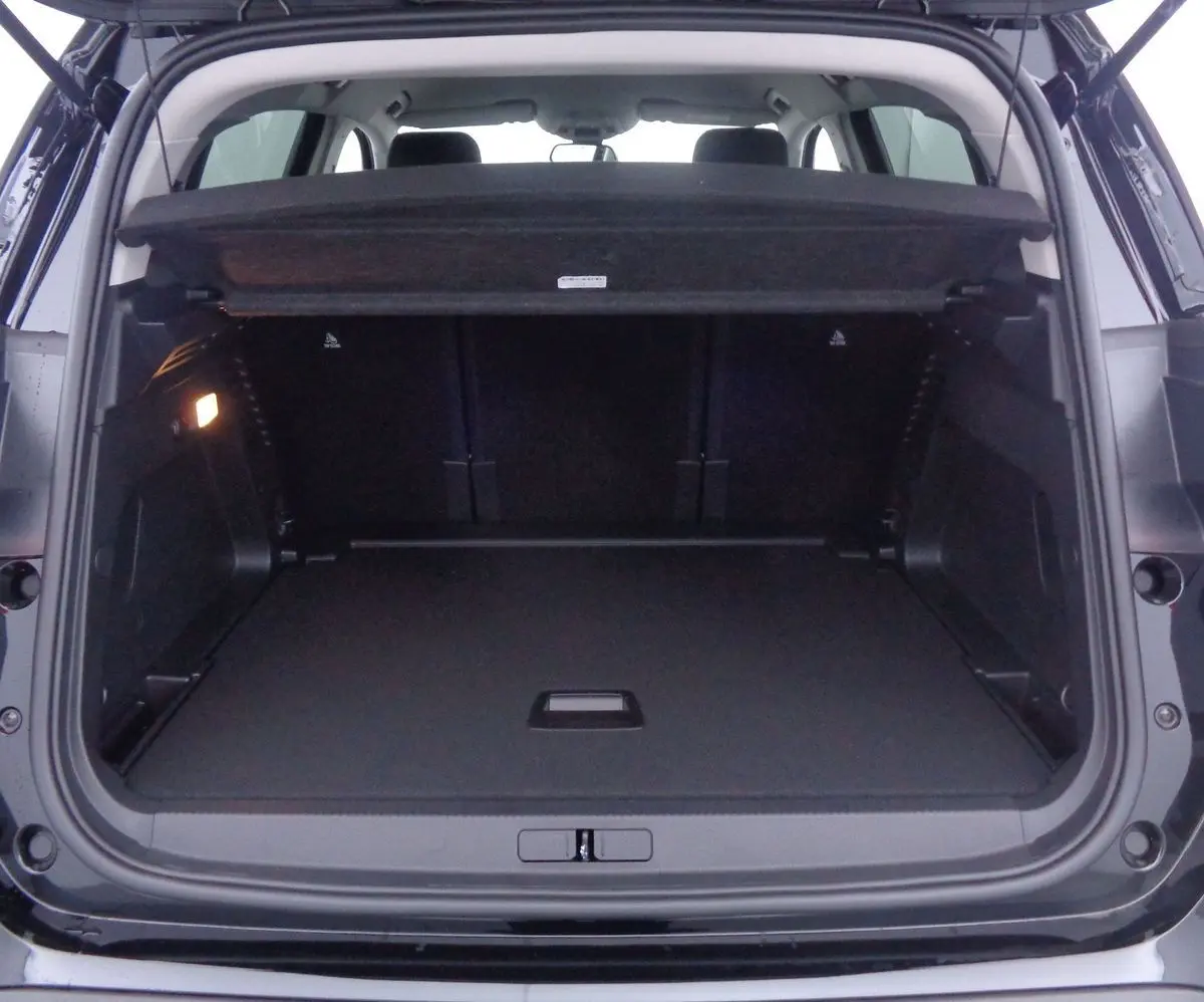 Coffre ouvert vu de l'arrière d'un Citroën C5 Aircross noir perle, montrant un espace de chargement spacieux et propre.