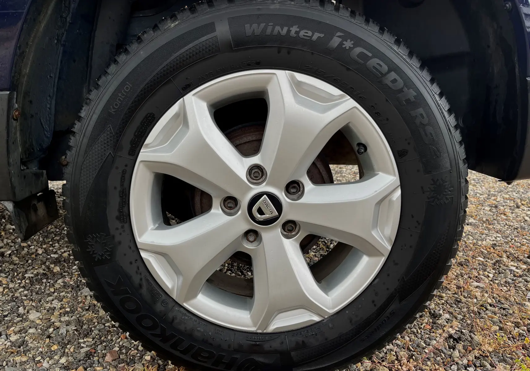 Gros plan sur la roue avant gauche d'un Dacia Duster bleu marine 2018 avec jante alliage et pneu hiver Hankook.