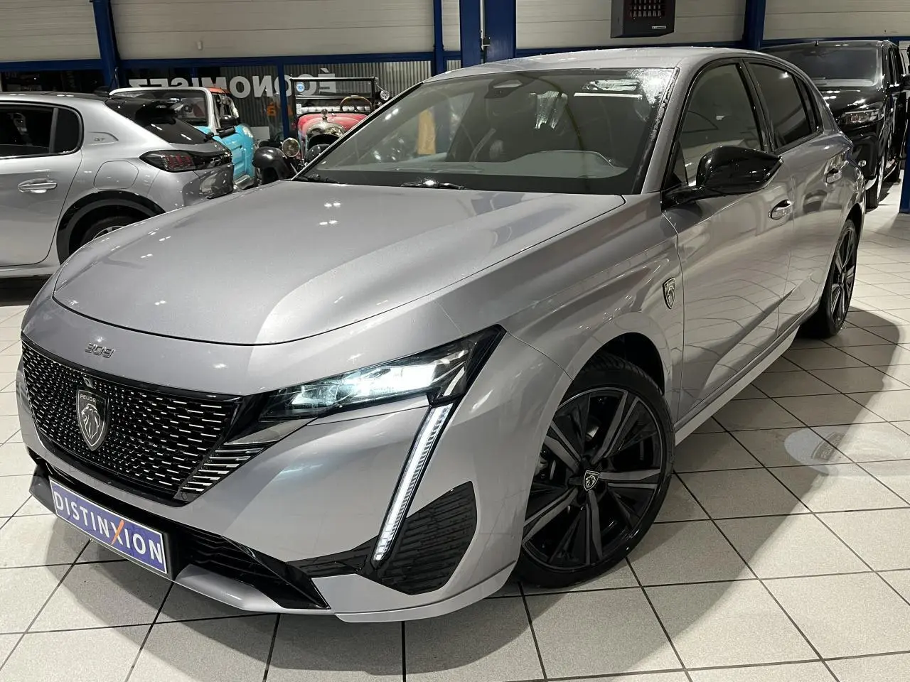 PEUGEOT 308 GT gris Artense en 3/4 avant droit, avec calandre noire vernie et jantes alliage noires.