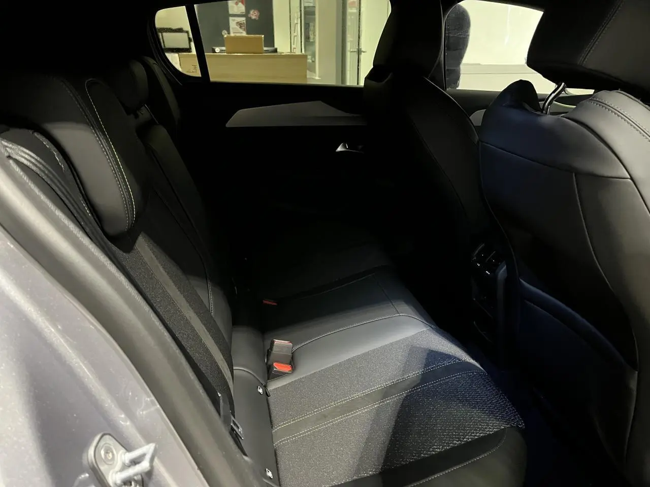 Vue côté gauche de la banquette arrière en tissu et cuir noir de la Peugeot 308 GT gris Artense 2024.