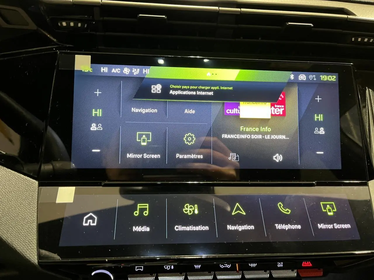 Vue intérieure du tableau de bord tactile de la Peugeot 308 GT 2024 avec écran multimédia et commandes climatisation.