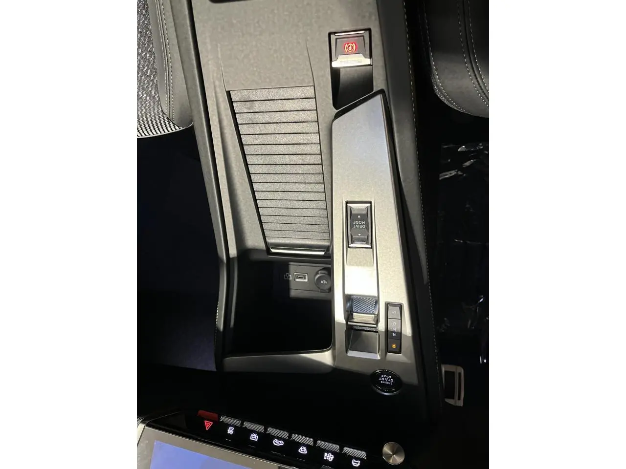 Vue plongeante de la console centrale gris aluminium de la Peugeot 308 GT 2024 avec commandes de boîte auto et prise 12V visible