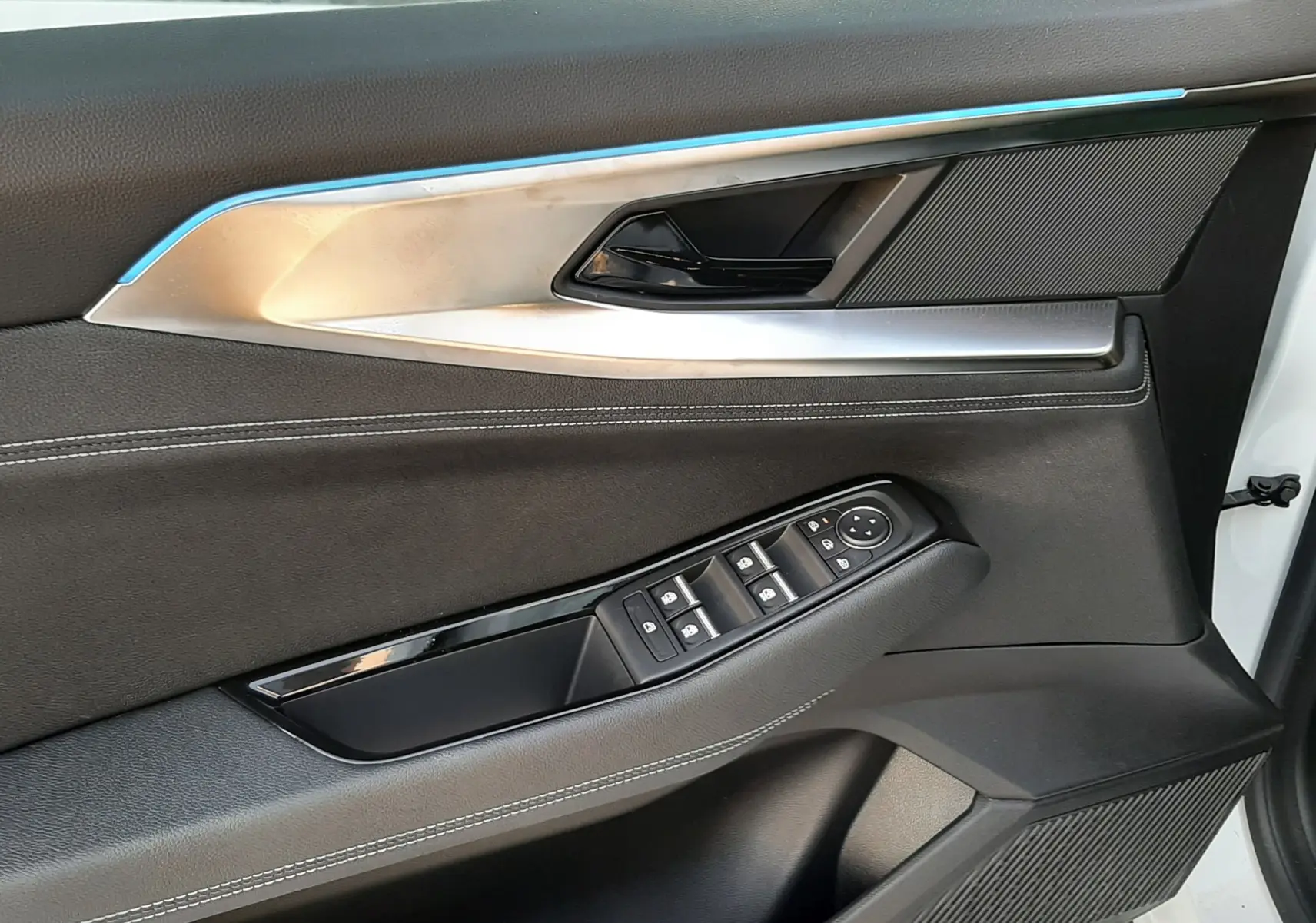 Intérieur côté gauche de la porte Renault Austral 2025 blanc nacré, avec commandes électriques et insert argenté.