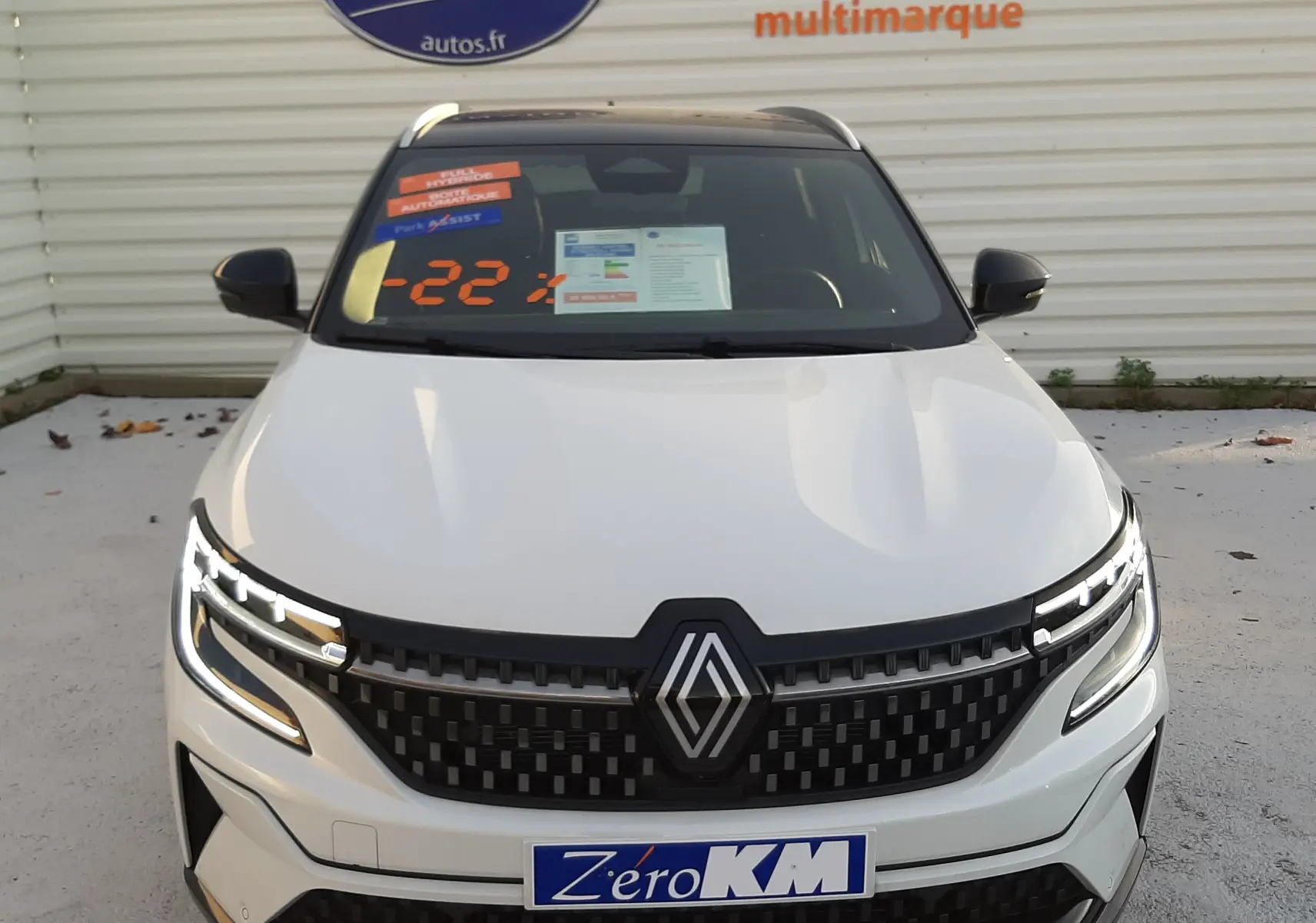 Vue de face du Renault Austral 2025 blanc nacré avec toit noir, mettant en valeur sa calandre moderne et ses phares LED fins.