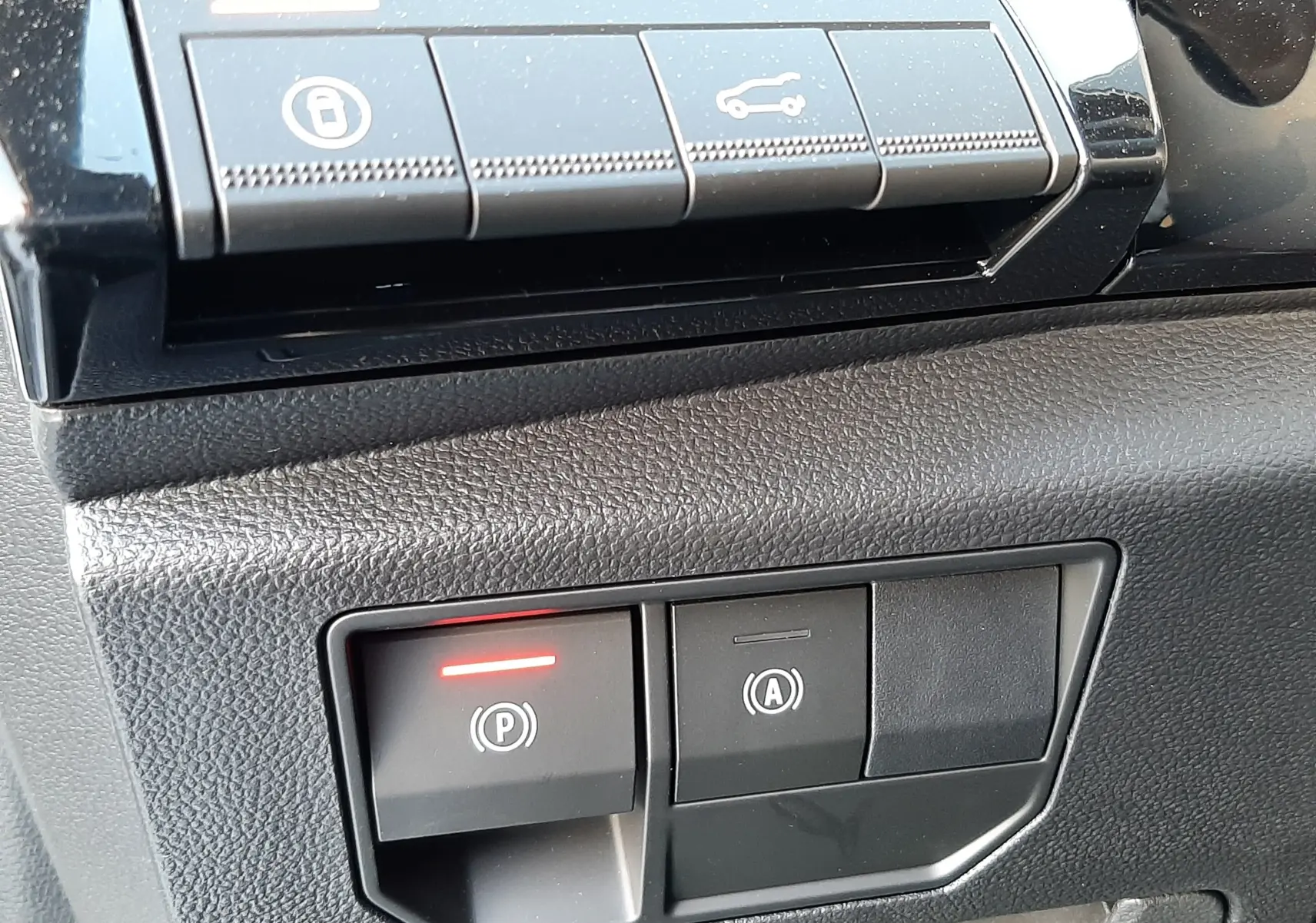 Gros plan sur les commandes de frein à main électronique et démarrage automatique du Renault Austral E-Tech blanc nacré.