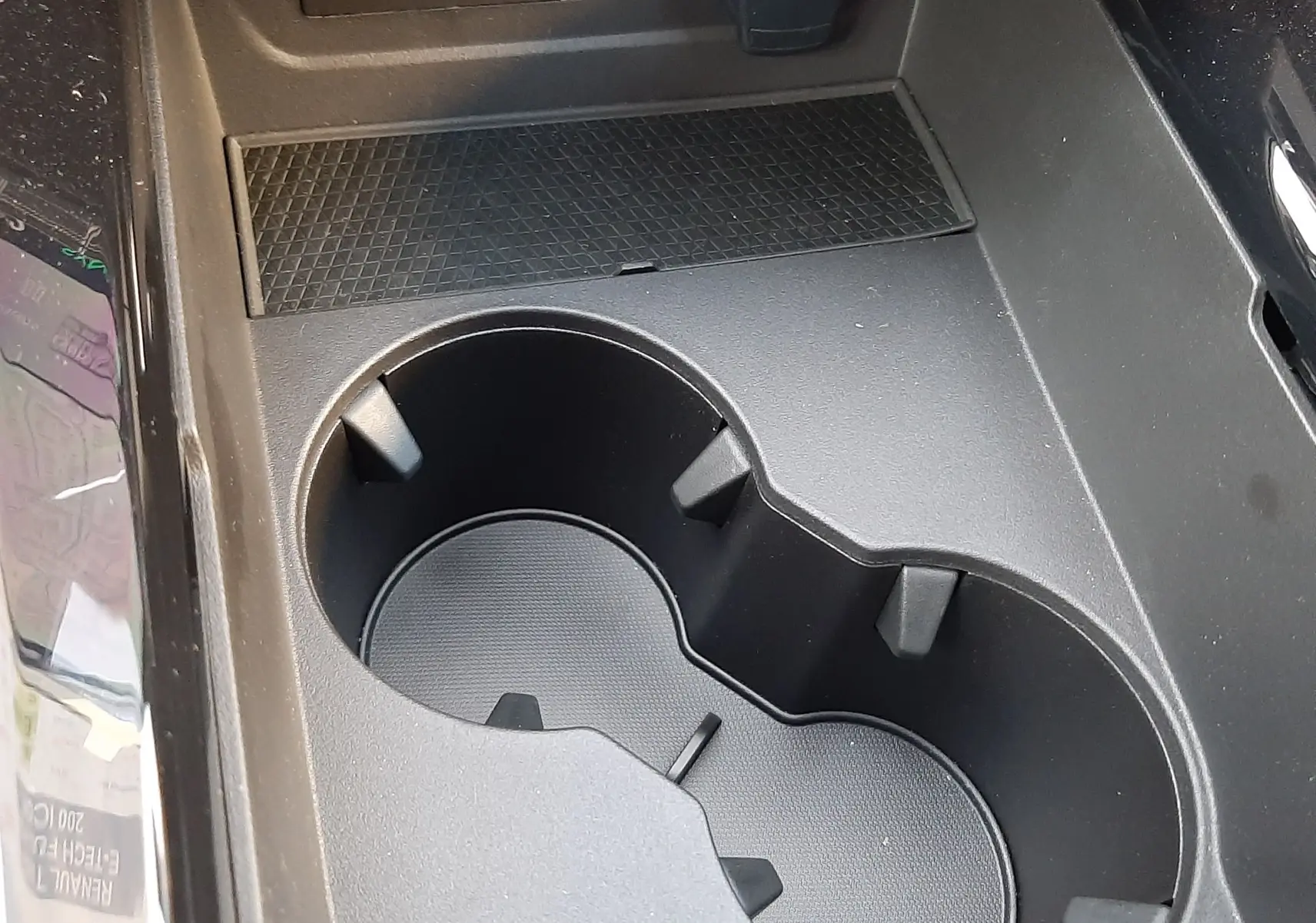 Gros plan sur la console centrale noire du Renault Austral 2025, avec porte-gobelets et ports USB visibles.