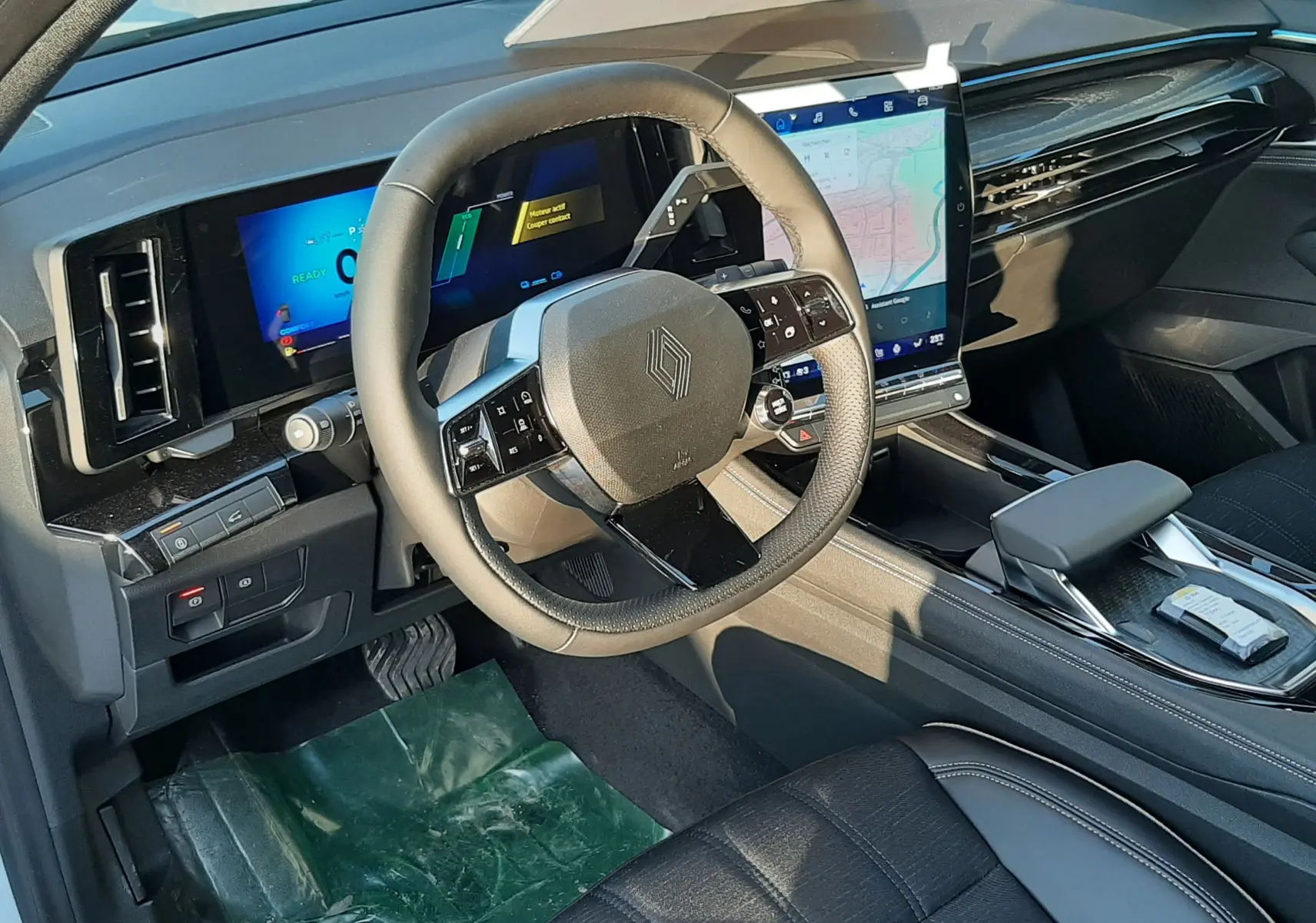 Vue 3/4 arrière droite d'un Renault Austral 2025 blanc nacré avec toit noir et jantes alliage, stationné sur sol mouillé.