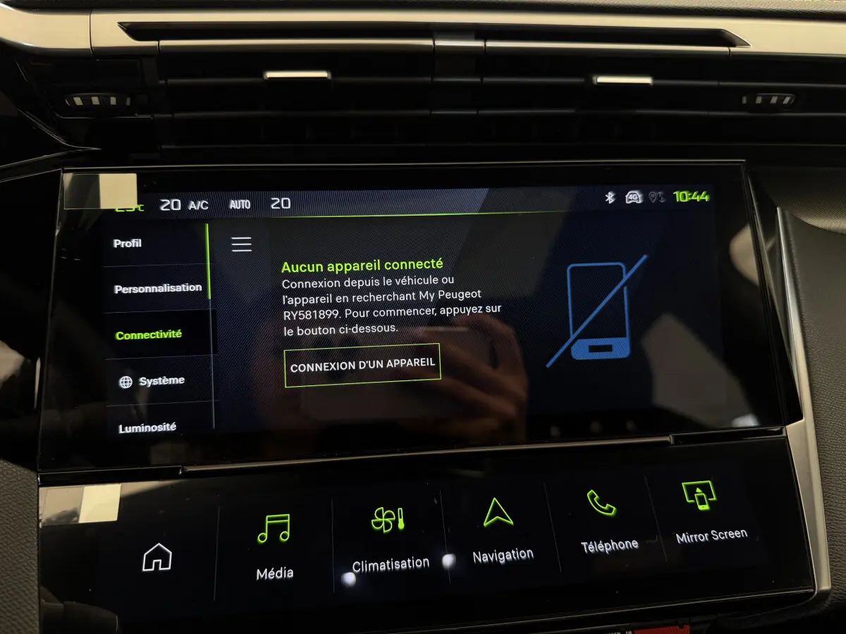 Écran tactile central de la Peugeot 308 Hybrid 2024 affichant le menu connectivité avec interface noire et icônes vertes.