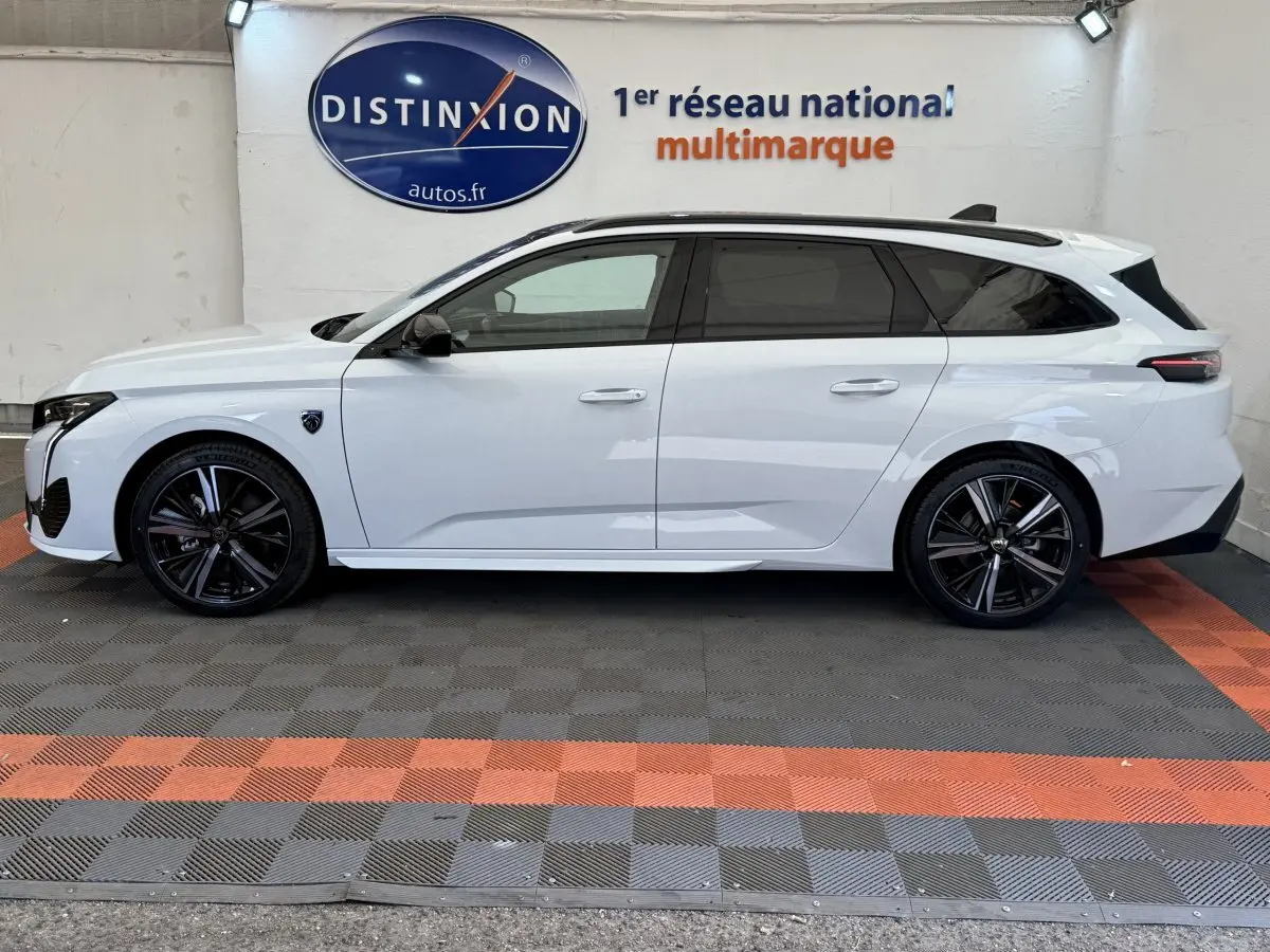 Peugeot 308 Hybrid 136 e-DCS6 GT blanc vue de profil côté gauche avec jantes noires et toit ouvrant.