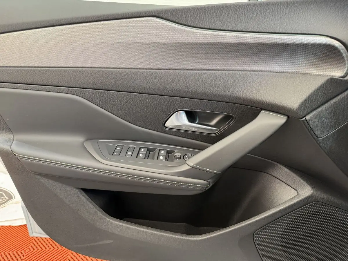 Vue rapprochée de la porte avant gauche intérieure noire de la Peugeot 308 Hybrid 136 e-DCS6 GT 2024.