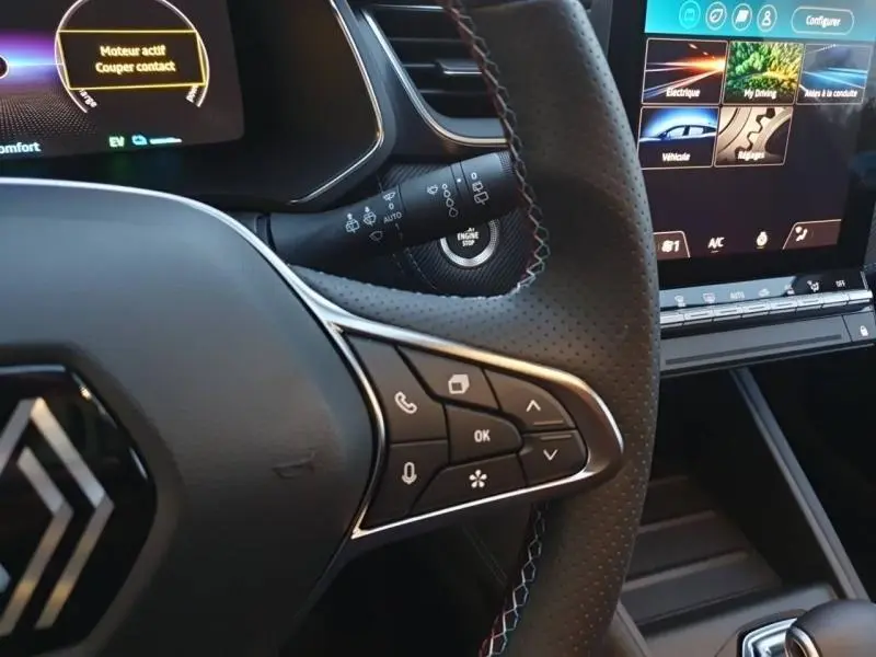 Gros plan sur le volant cuir perforé avec commandes multifonctions et écran tactile du tableau de bord du Renault Captur Bleu Iron 2025.