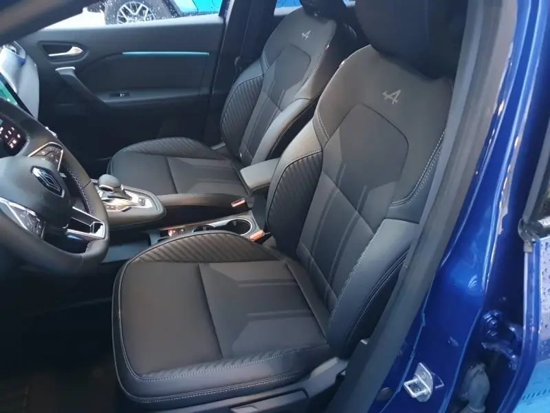 Vue intérieure côté conducteur du Renault Captur Bleu Iron 2025, sièges sport esprit Alpine en cuir noir avec logo brodé.