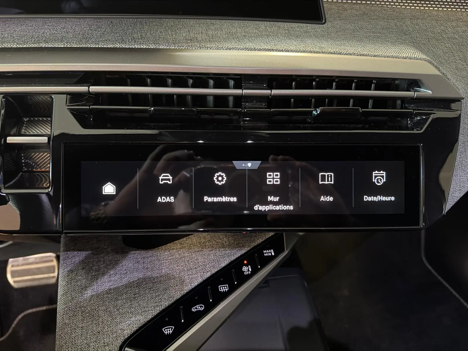 Vue rapprochée de l’écran tactile central et de la console du Peugeot 5008 Hybrid 145 e-DCS6 GT avec finition tissu gris.