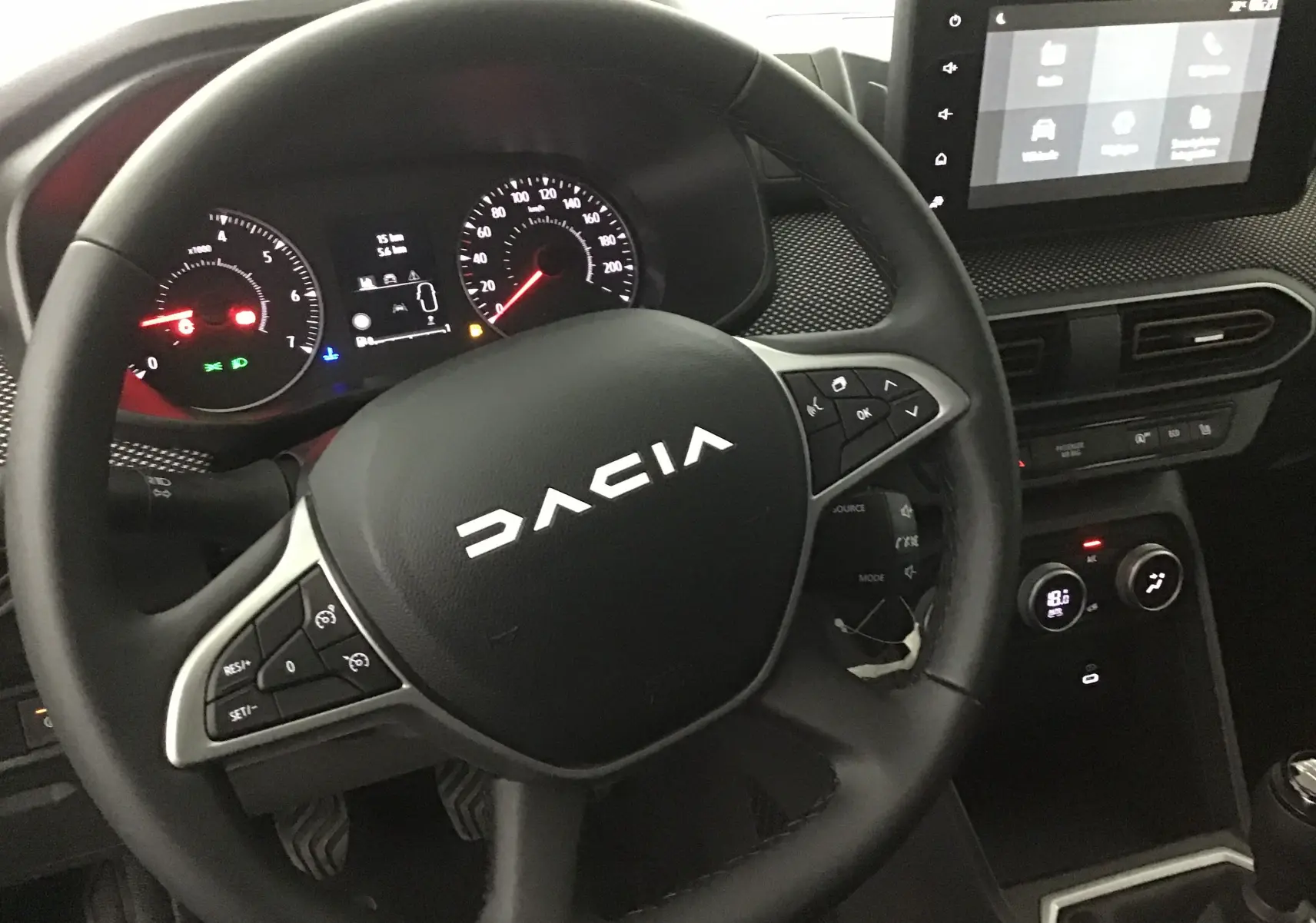 Vue intérieure centrée sur le volant DACIA d'une Sandero Stepway 2025 avec tableau de bord et écran tactile.