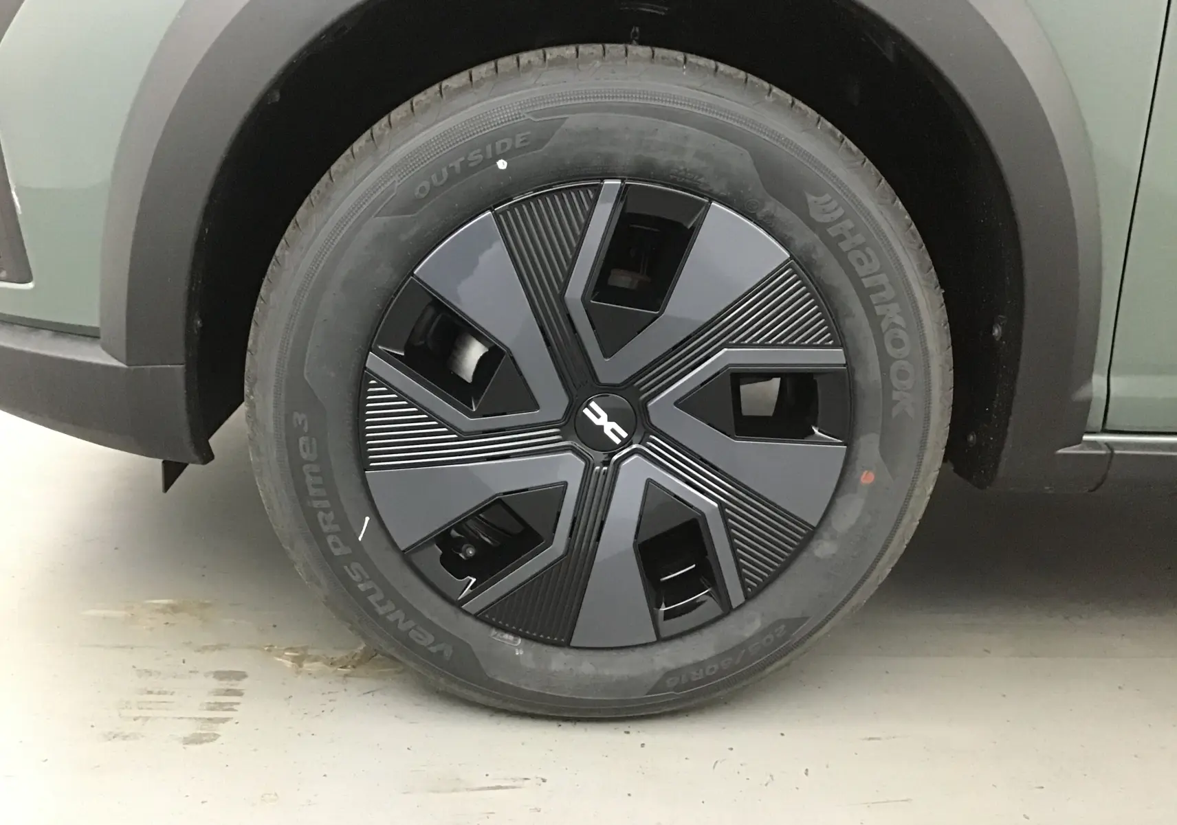 Gros plan sur la roue avant droite d'une Dacia Sandero Stepway 2025 kaki avec jante noire au design moderne.