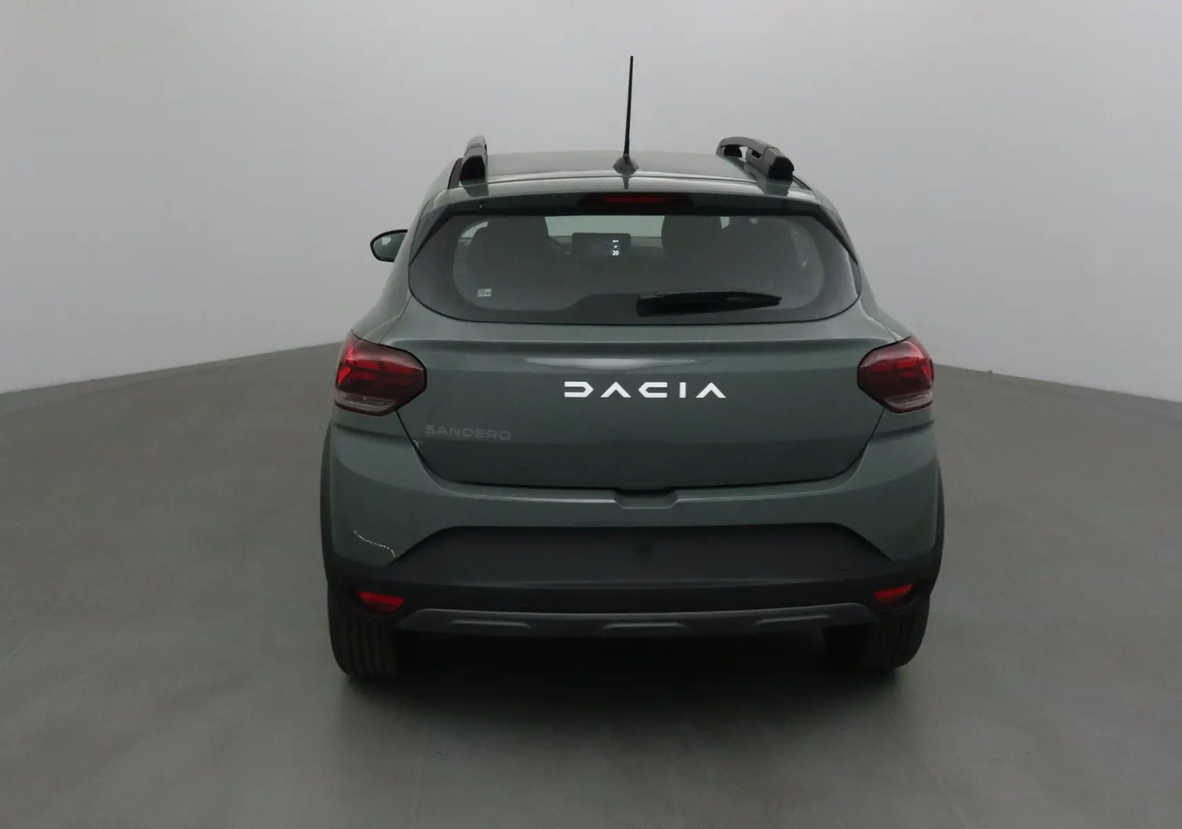 Vue arrière d'une Dacia Sandero Stepway 2025 en kaki Kichen avec barres de toit et feux rouges distinctifs.