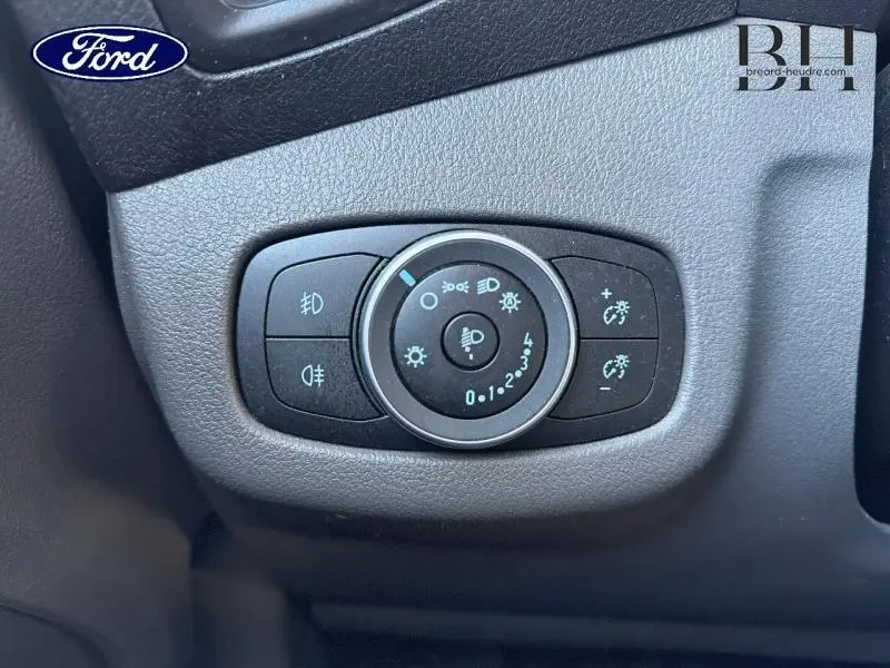 Gros plan sur la commande des phares et éclairages du tableau de bord du Ford Transit Connect blanc glacier 2022.