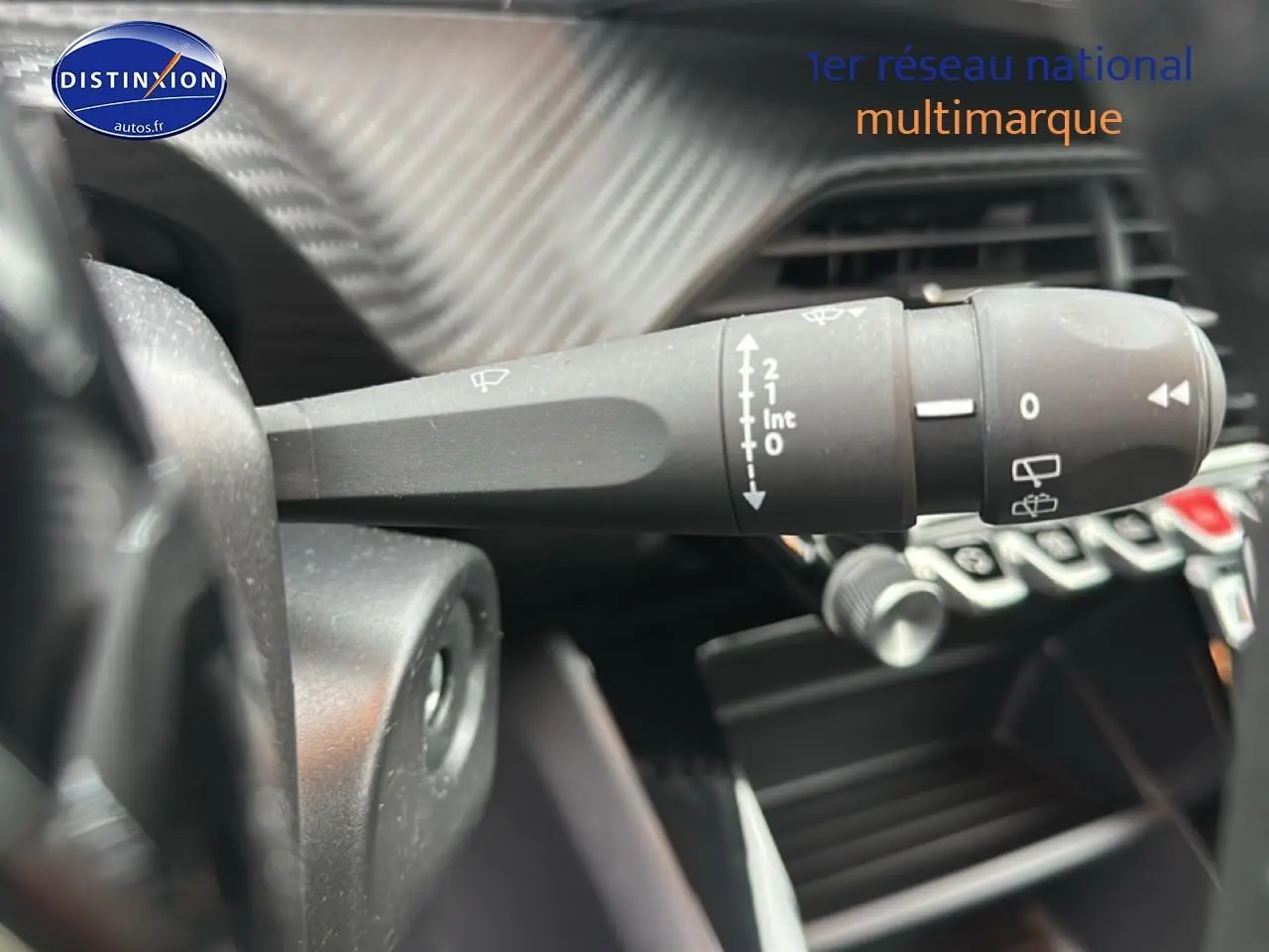 Gros plan sur la commande d’essuie-glace dans l’habitacle d’une Peugeot 208 gris Artense 2024.