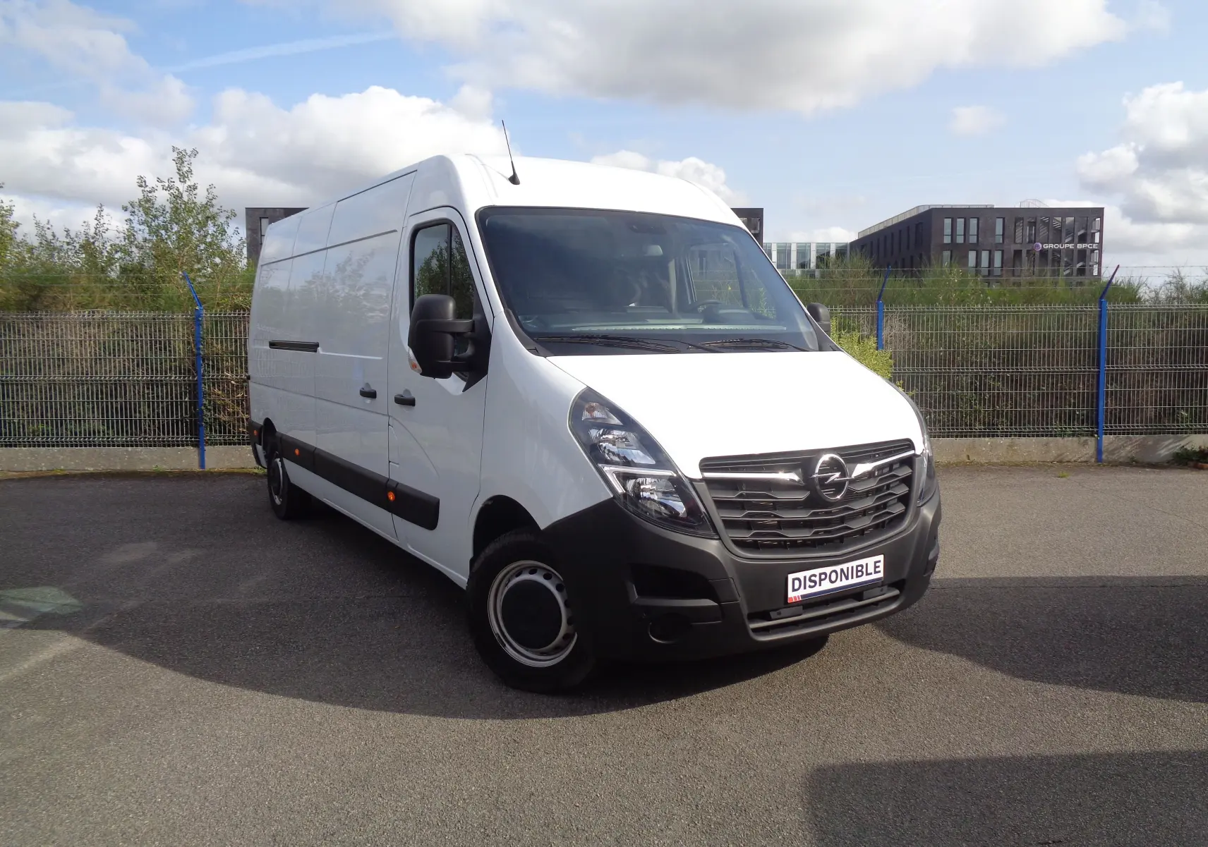 Fourgon Opel Movano blanc polaire vu en 3/4 avant droit, avec calandre noire et plaque "DISPONIBLE" visible.