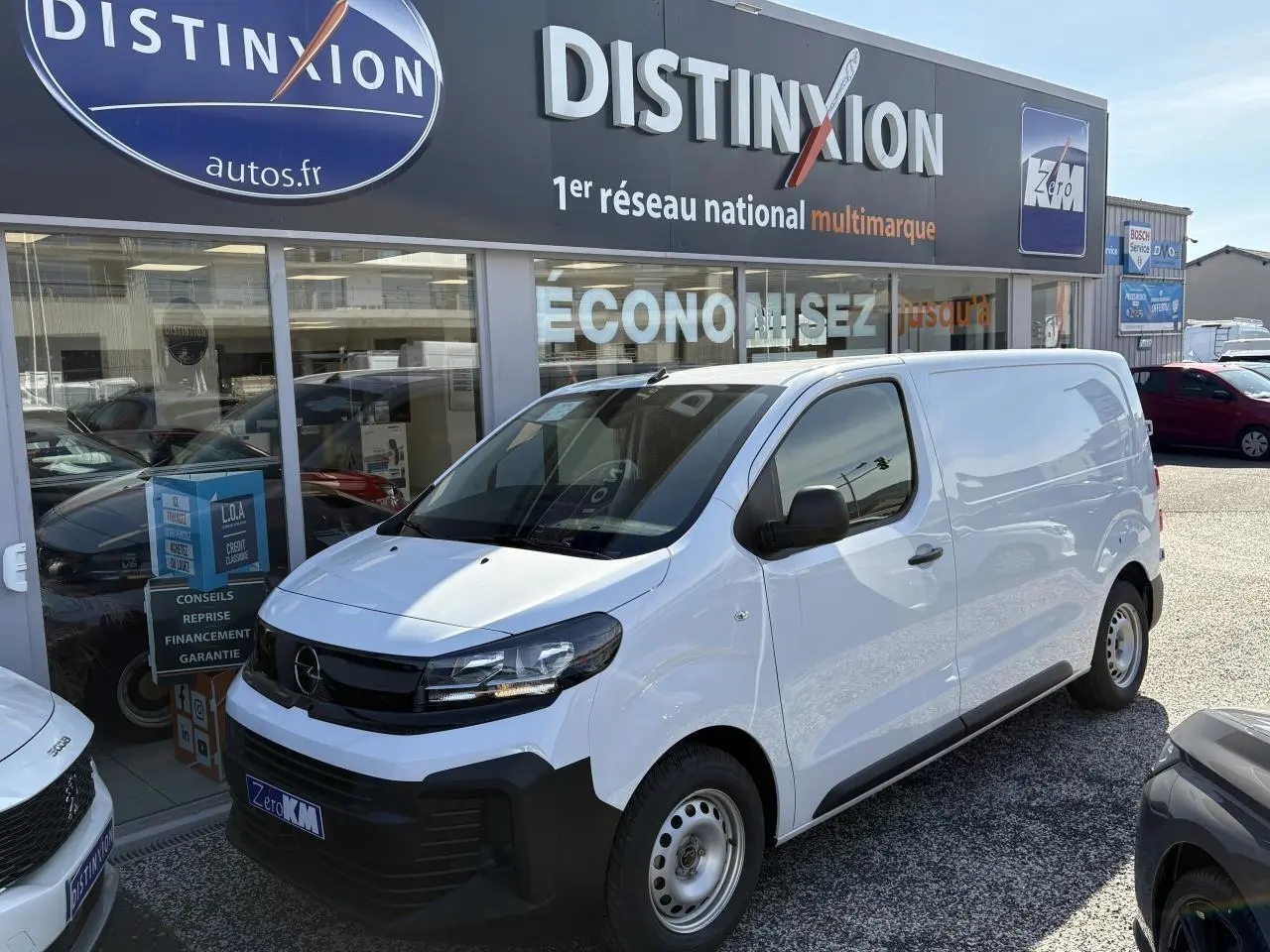 Opel Vivaro blanc vue 3/4 avant droit, utilitaire compact avec calandre noire et jantes acier simples.