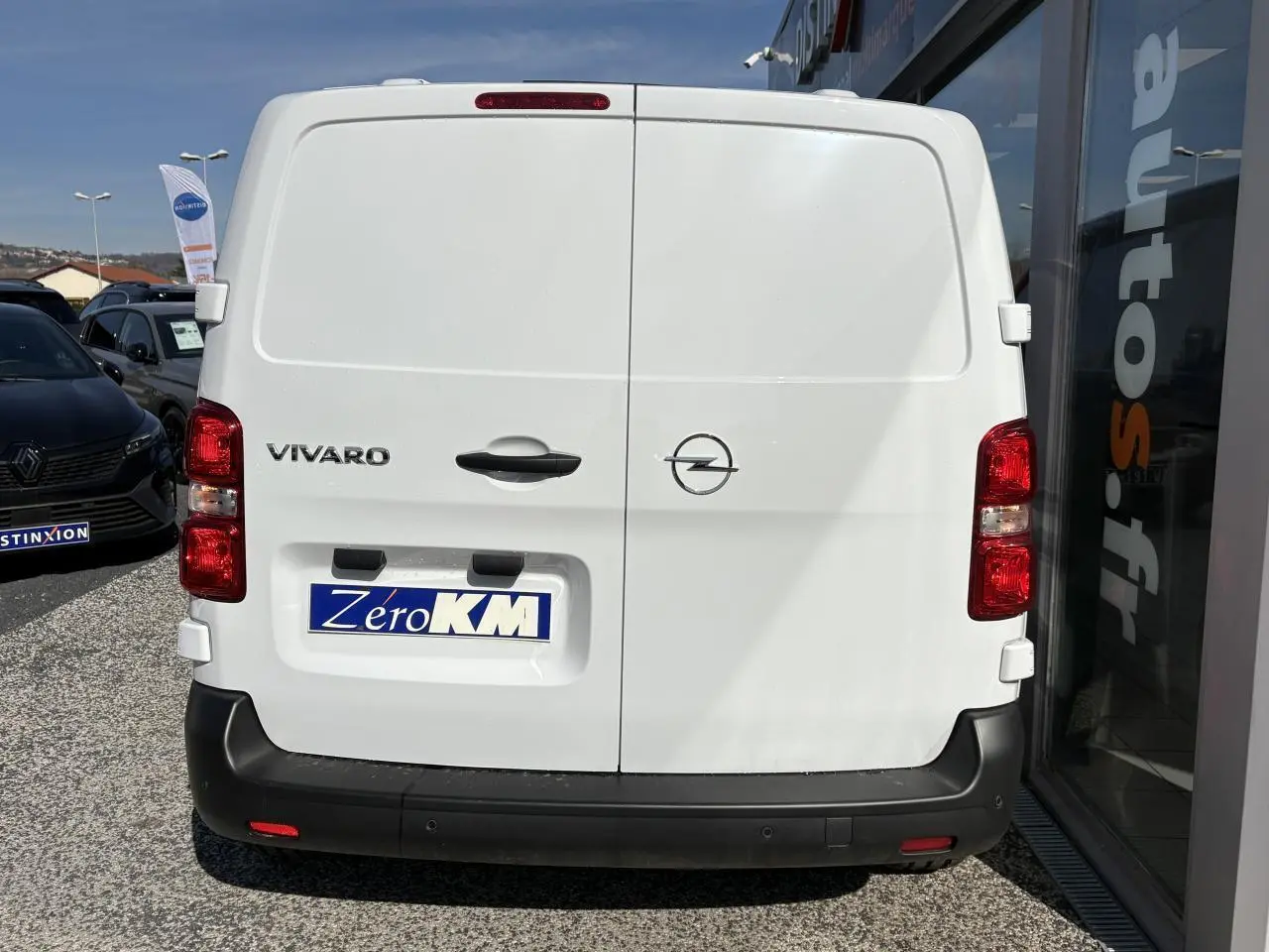 Vue arrière d’un utilitaire Opel Vivaro blanc avec portes battantes et pare-chocs noir.