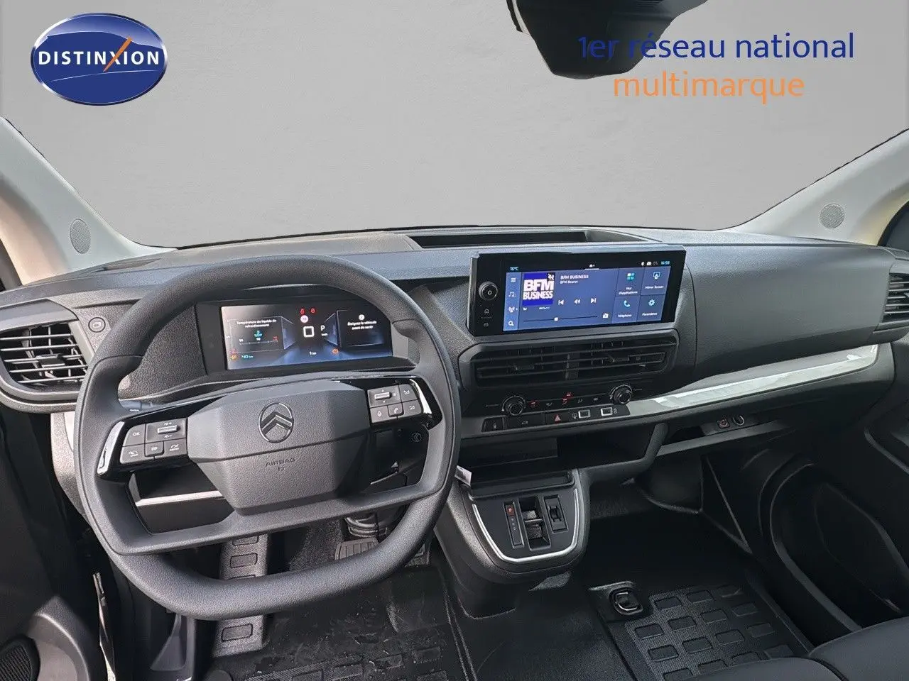 Vue intérieure du poste de conduite du Citroën Jumpy Fourgon gris titane, avec tableau de bord numérique et écran tactile central.