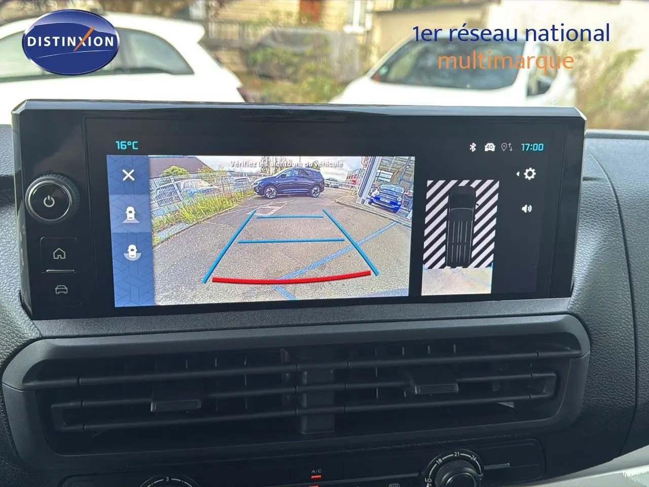 Écran central affichant la caméra de recul et l'alerte de proximité dans un Citroën Jumpy Fourgon gris titane, vue intérieure.