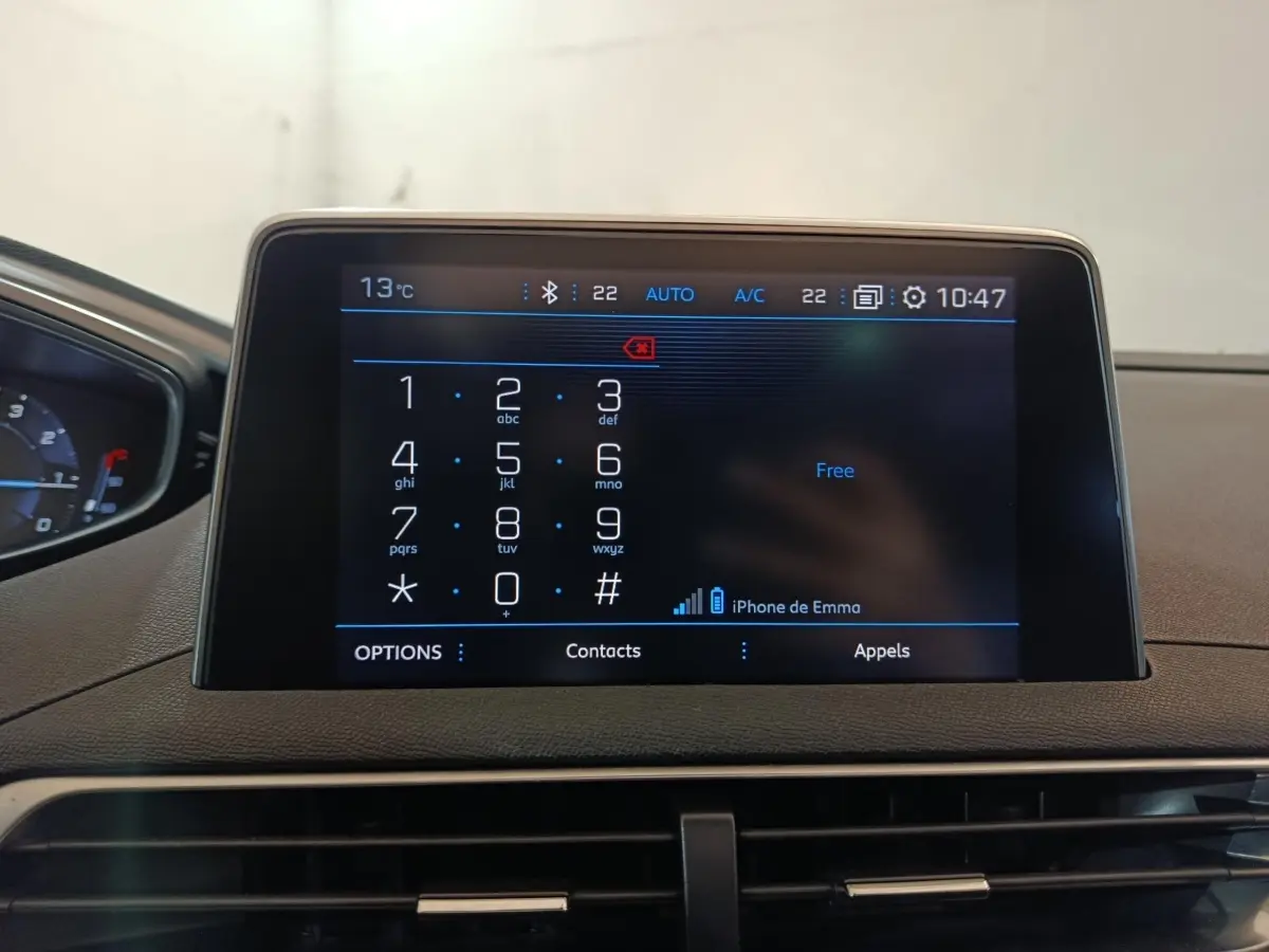 Écran tactile central du tableau de bord du Peugeot 3008 blanc, affichant le clavier téléphonique et la connexion Bluetooth.