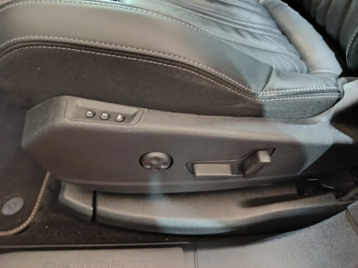 Gros plan sur les commandes de réglage électrique du siège avant noir du Peugeot 3008 blanc, version Allure 2019.