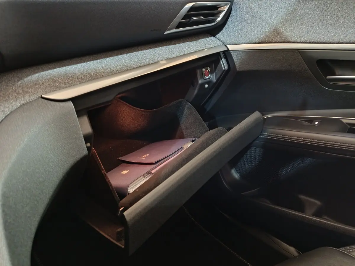 Gant de boîte à gants ouvert côté passager dans l’habitacle noir du Peugeot 3008 blanc, version Puretech 130.