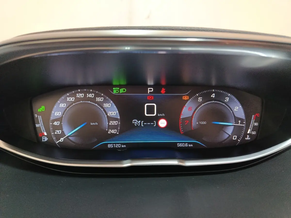 Tableau de bord numérique du Peugeot 3008 blanc, affichage vitesse, compte-tours et indicateurs lumineux.