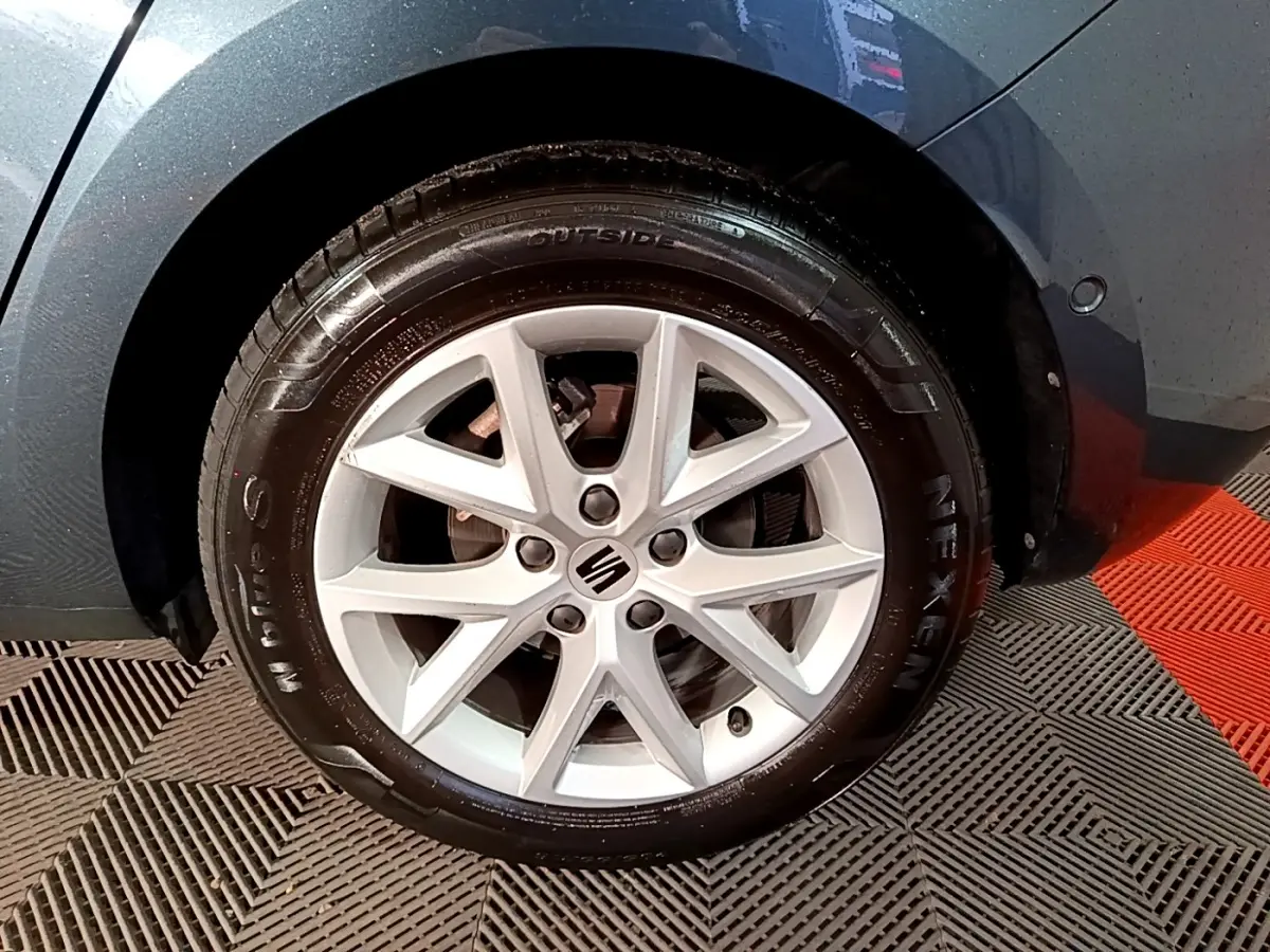 Gros plan sur la roue avant droite grise d'une SEAT LEON 2023 avec jante alliage à 5 doubles branches.