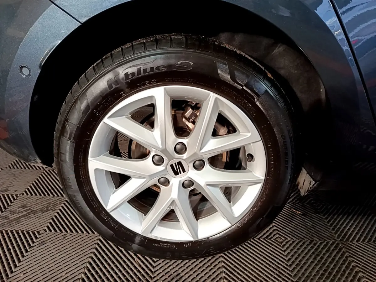 Gros plan sur la roue avant droite gris clair d'une SEAT LEON 2023 avec jante alliage à 5 doubles branches.