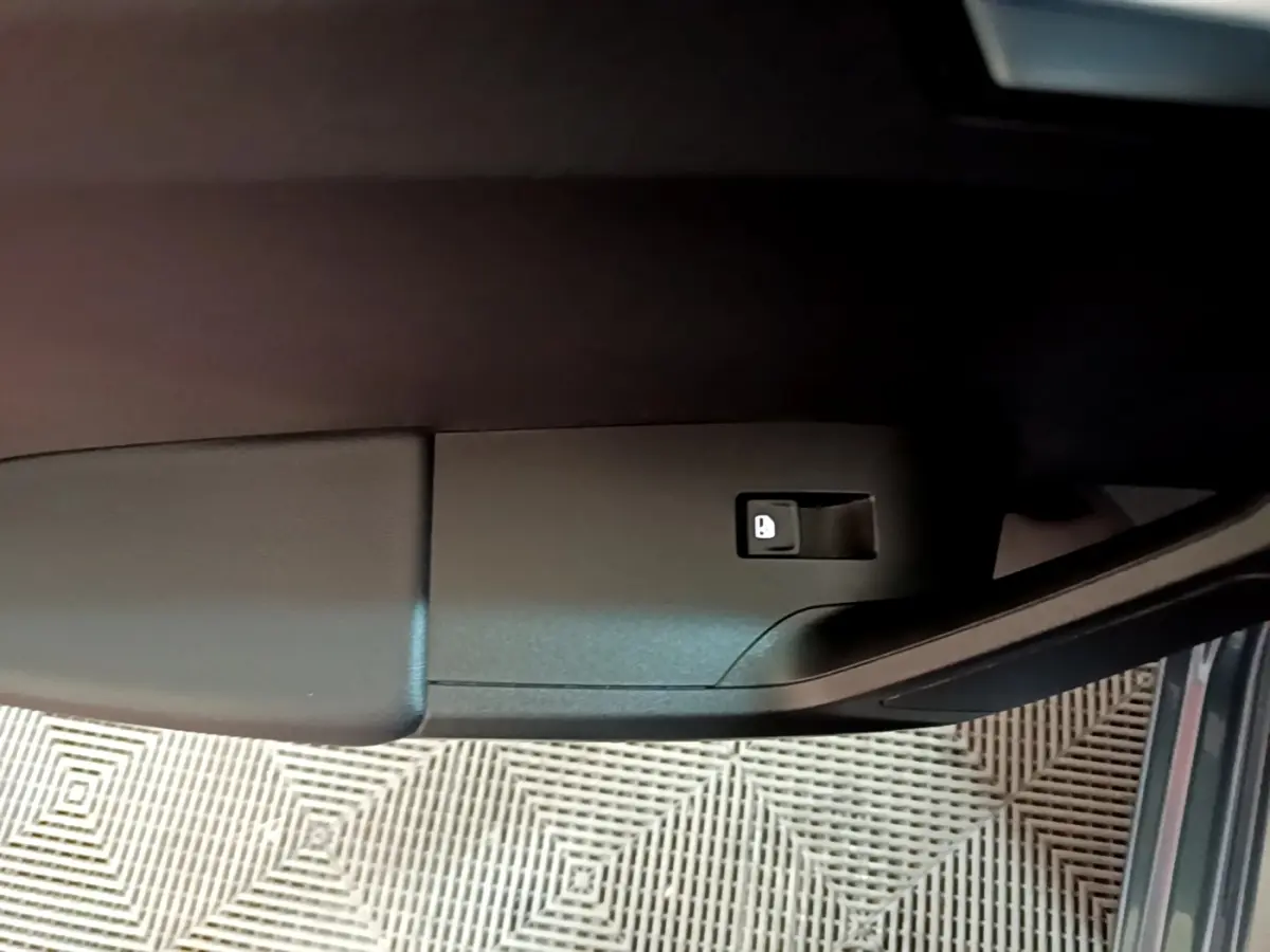 Détail de la commande de verrouillage sur la portière avant gauche d’une SEAT Leon gris clair 2023.