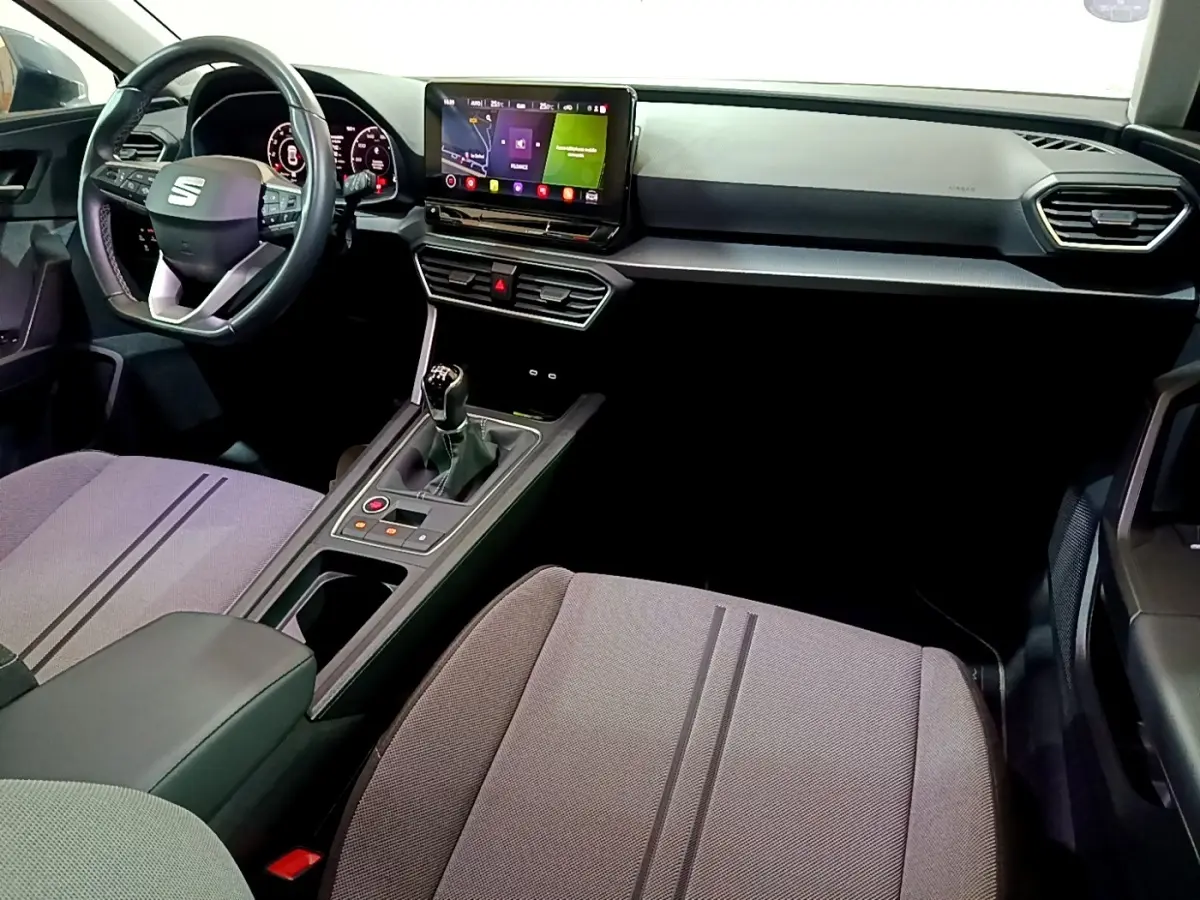 Vue intérieure avant droite du tableau de bord et console centrale d'une SEAT Leon gris clair avec boîte manuelle et écran tactile.