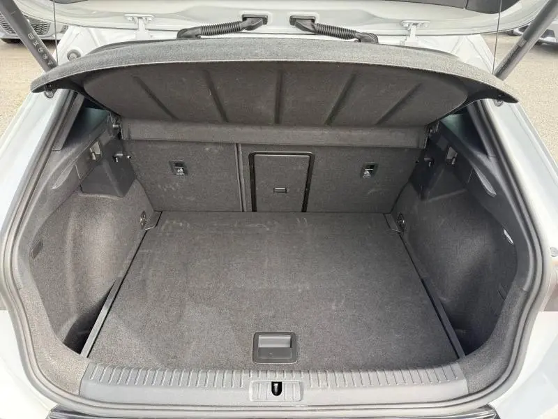 Coffre ouvert vu de l'arrière d'un CUPRA Formentor blanc Nevada métallisé, montrant un espace de chargement propre et spacieux.