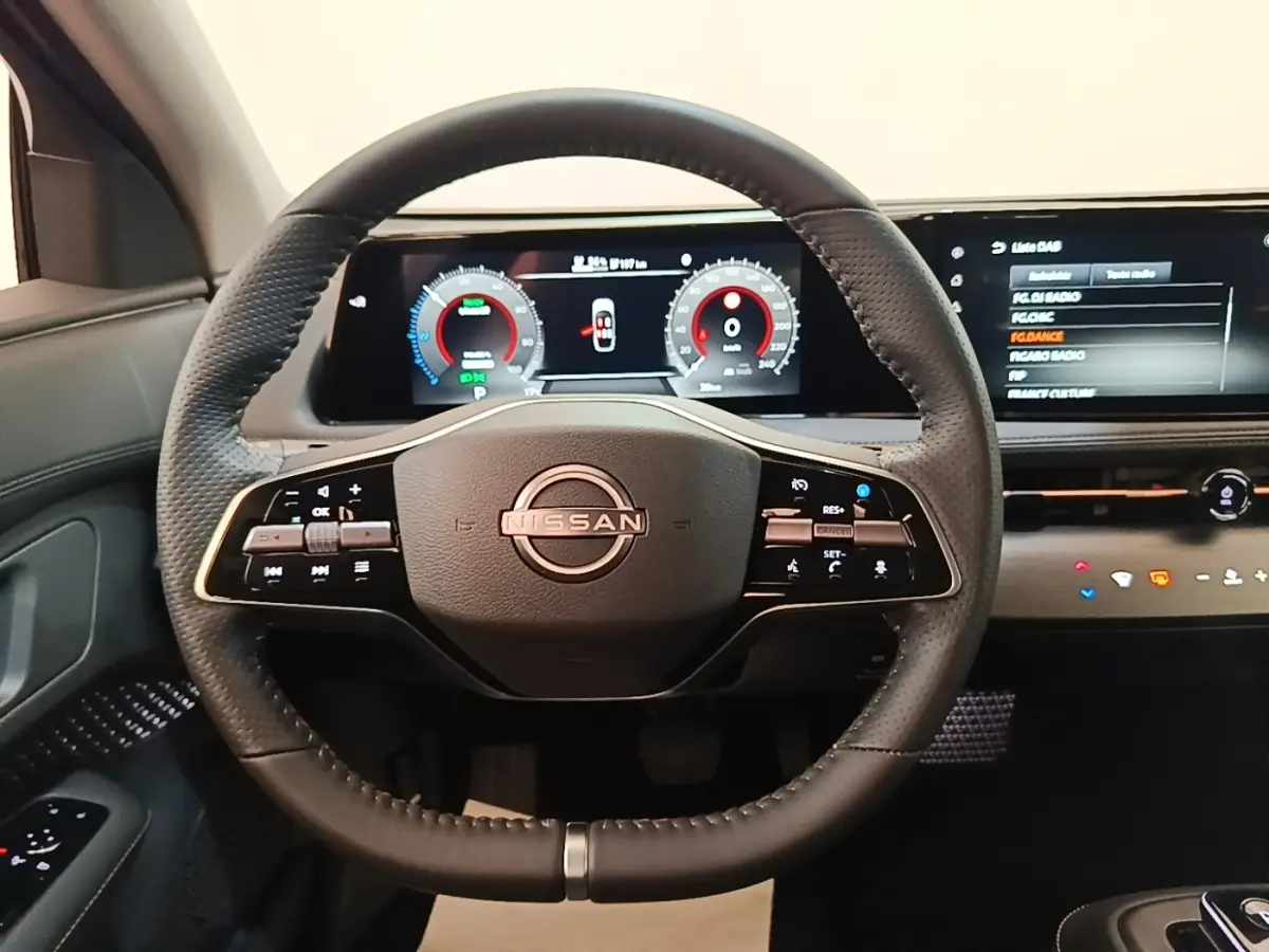 Vue frontale du volant cuir noir multifonctions du Nissan Ariya 2026 avec tableau de bord numérique et écran tactile.