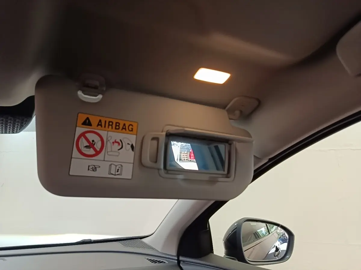 Détail intérieur du pare-soleil côté conducteur avec miroir éclairé et rétroviseur extérieur noir visible sur Nissan Ariya noir.