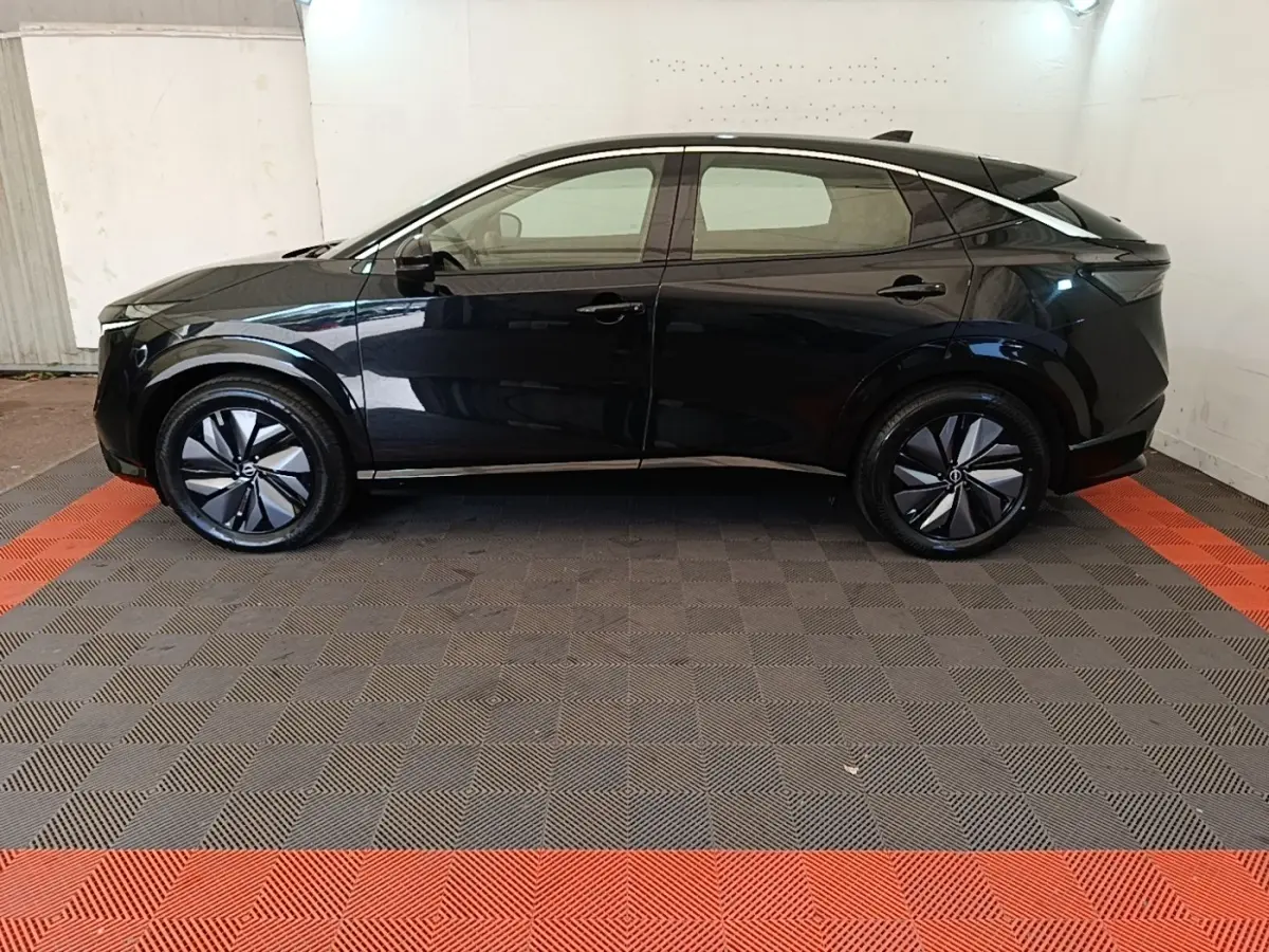 Vue de profil côté gauche du Nissan Ariya noir 63kWh 218ch Engage avec jantes modernes et lignes épurées.