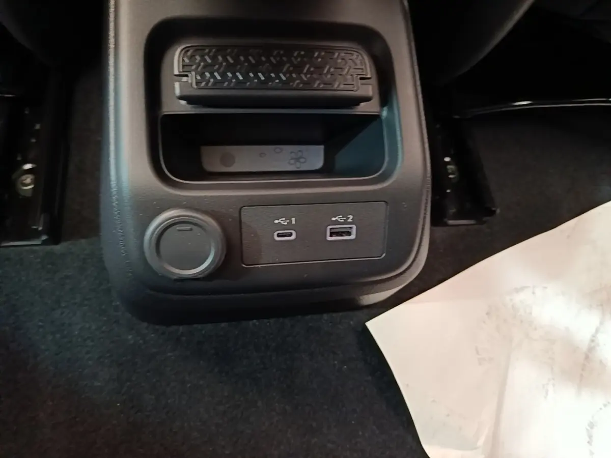 Vue rapprochée du rangement arrière avec prises USB-C et USB-A du Nissan Ariya noir 63kWh 218ch Engage 2026.