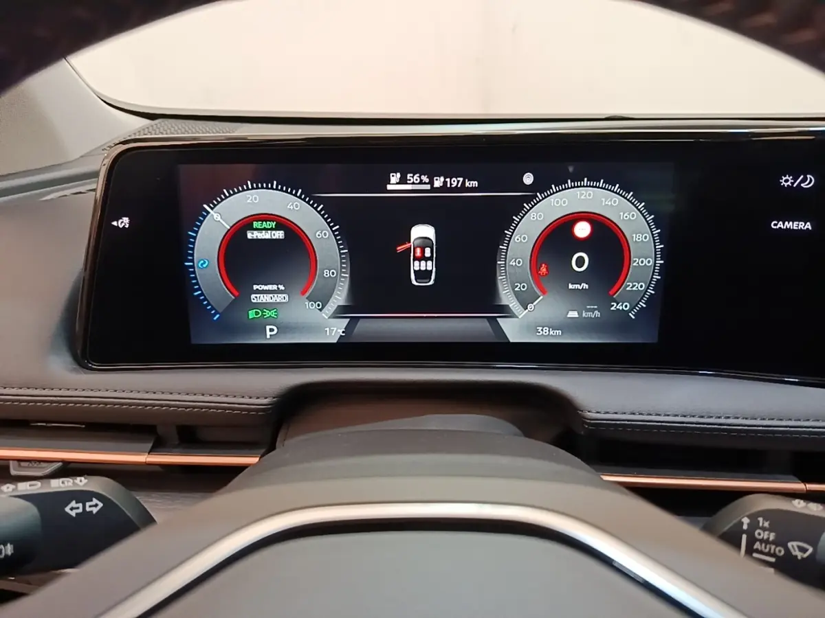 Vue rapprochée du tableau de bord numérique du Nissan Ariya noir 2026, affichage multifonctions et vitesse à 0 km/h.