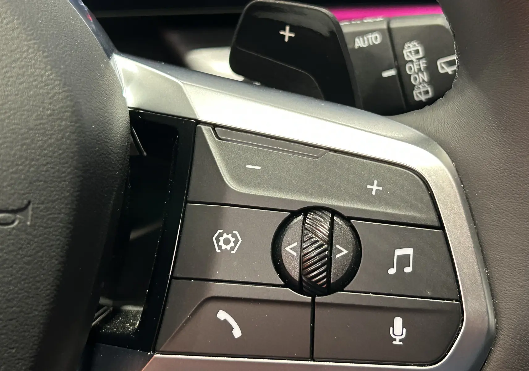 Gros plan sur les commandes au volant du BMW X1 2024, avec molette et boutons multifonctions en finition M Sport.