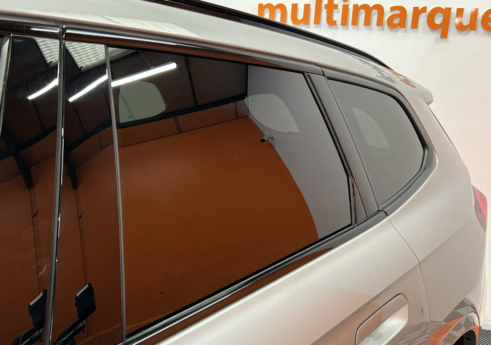 Vue latérale arrière droite d'un BMW X1 Spacesilber avec vitres teintées et poignées affleurantes M Sport.