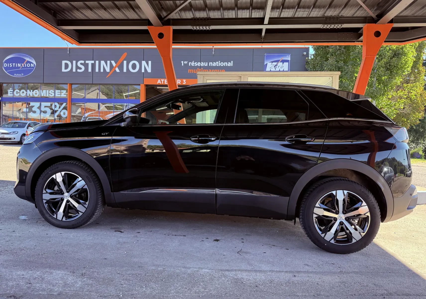Peugeot 3008 noir perle métal vue de profil côté gauche sous un abri avec jantes alliage bicolores.