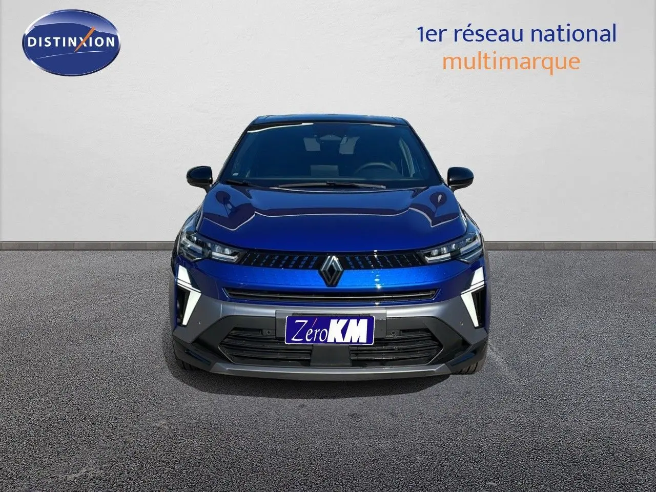Vue frontale d'un Renault Captur E-Tech hybride bleu Iron Metal avec toit noir, éclairage LED et calandre moderne.