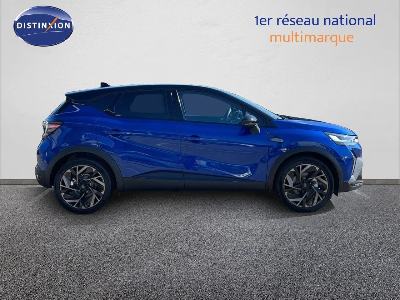 Profil côté gauche du Renault Captur E-Tech hybride 2025 en bleu Iron Metal avec toit noir et jantes stylées.