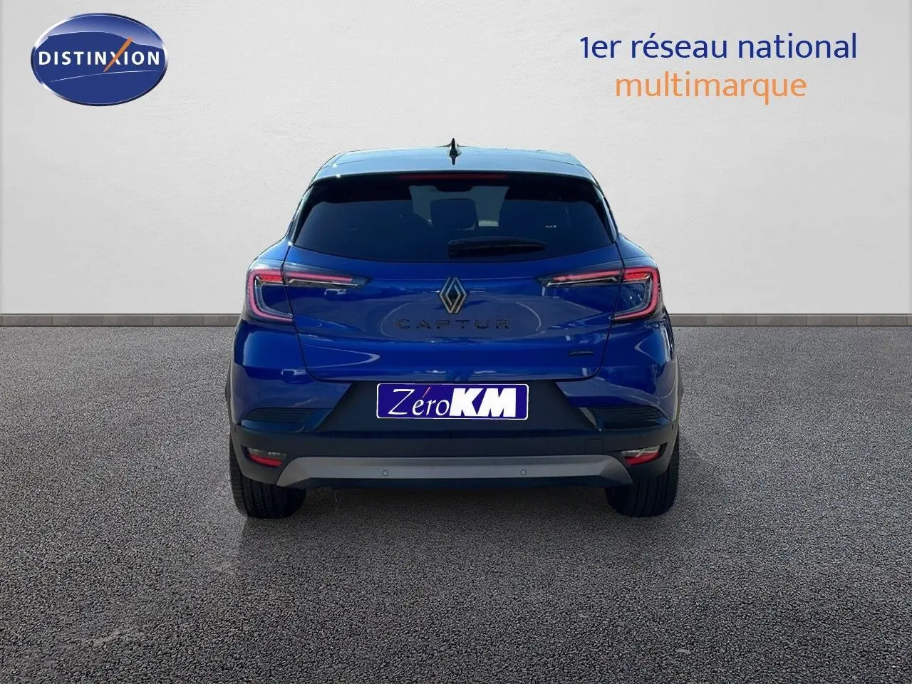 Vue arrière du Renault Captur E-Tech hybride 2025 en bleu Iron Metal avec toit noir, sur fond neutre.